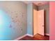 Bedroom with pink and teal walls, closet, and wood flooring at 32702 View Haven Ln, Sorrento, FL 32776