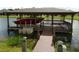 Private boat dock on a serene lake, complete with covered storage, boat lift, and a wooden walkway at 4904 Blanche Ct, Saint Cloud, FL 34772