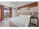 Bright bedroom with balcony access and bedside tables with lamps and clocks, lovely art at 7713 Graben St, Kissimmee, FL 34747