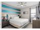 Relaxing bedroom offers a padded headboard, ceiling fan and natural light from a window at 7713 Graben St, Kissimmee, FL 34747