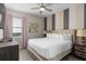 Inviting bedroom featuring a padded headboard, ceiling fan, and a decorative accent wall at 7713 Graben St, Kissimmee, FL 34747