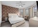Comfortable bedroom featuring a decorative accent wall, a ceiling fan and natural light at 7713 Graben St, Kissimmee, FL 34747