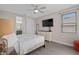Relaxing bedroom with neutral tones, TV, and ensuite bath, providing a comfortable retreat at 7713 Graben St, Kissimmee, FL 34747