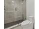 Bathroom with a frameless shower, gray tile, and white toilet at 6000 Tarawood Dr, Orlando, FL 32819