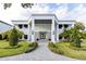 Modern two-story home with a white facade, gray stone accents, and a landscaped lawn at 6000 Tarawood Dr, Orlando, FL 32819