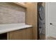 Modern laundry room with stacked washer and dryer, white countertop, and wood cabinets at 6000 Tarawood Dr, Orlando, FL 32819