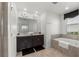Bright bathroom features a double vanity, a soaking tub, and neutral tones for a relaxing atmosphere at 1065 Splash Shot Pl # 1801, Davenport, FL 33896
