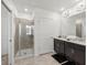 Well-lit bathroom featuring double sinks, decorative mirrors, and a glass shower at 1065 Splash Shot Pl # 1801, Davenport, FL 33896