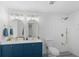 Modern bathroom with white subway tiles, a blue vanity, and gold fixtures at 36 Camellia Dr, Ormond Beach, FL 32176