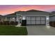 Single-story home with gray garage door and landscaped lawn at 145 Lewis Dr, Davenport, FL 33837