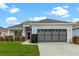 Single story home with gray garage door and well-manicured lawn at 145 Lewis Dr, Davenport, FL 33837