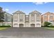 Low-rise residential building with garage parking, well-maintained landscaping, and a neatly paved parking area at 12825 Madison Pointe Cir # 205, Orlando, FL 32821