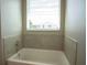 Clean bathroom featuring a bathtub and tiled walls at 1676 Andover Ridge Dr, Deland, FL 32720