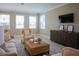 Spacious living room with large windows, neutral decor, and a stylish media console at 1676 Andover Ridge Dr, Deland, FL 32720