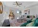 Bright living room with a modern sofa, teal chairs, decorative rug, and decorative artwork at 6340 Chorus Dr, Mascotte, FL 34753