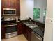 Charming kitchen with stainless steel appliances, dark granite countertops, and cherry wood cabinets at 14501 Grove Resort Ave # 1105, Winter Garden, FL 34787