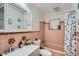 This retro bathroom has light pink tiling and a contrasting brown trim and vanity details at 1817 W Grant St, Orlando, FL 32805