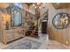Grand foyer featuring stone accent wall, curved staircase, unique lighting, and stylish decor at 208 Green Lake Cir, Longwood, FL 32779