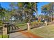 Ornate entrance gate opens to a home with a lake view at 39250 Forest Dr, Eustis, FL 32736