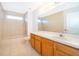 Well-lit bathroom featuring a tiled shower-tub combination and a vanity with wooden cabinets at 608 Abaco Ct, Kissimmee, FL 34746