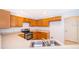 Well-lit kitchen features wood cabinets, modern stainless steel appliances and light countertops at 608 Abaco Ct, Kissimmee, FL 34746