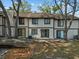 Exterior backyard view of the house, framed by trees, with visible windows and sliding glass doors at 4945 Sanoma Vlg # B, Orlando, FL 32808