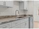 Updated kitchen with stainless steel appliances, white cabinets, and stone countertops at 4945 Sanoma Vlg # B, Orlando, FL 32808