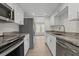 Updated kitchen featuring stainless steel appliances, stone countertops, and white cabinets at 4945 Sanoma Vlg # B, Orlando, FL 32808