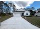 New construction home features a white exterior, driveway, and landscaping at 1112 Camden Way, Poinciana, FL 34758