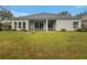 Home's backyard with a covered patio and a large grassy area, perfect for outdoor activities at 148 Blue Stone Cir, Winter Garden, FL 34787