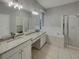 Bright bathroom featuring dual vanities, granite countertops, a bathtub, and a glass shower at 148 Blue Stone Cir, Winter Garden, FL 34787