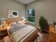 Cozy bedroom with a queen bed, a window view of the yard, and modern decor at 148 Blue Stone Cir, Winter Garden, FL 34787