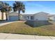 Charming single-story home featuring stucco walls, a two-car garage, and mature palm trees in the front yard at 759 Little Wekiva Cir, Altamonte Springs, FL 32714