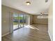 Bright living room featuring wood flooring, fan, and sliding glass doors leading to the backyard at 759 Little Wekiva Cir, Altamonte Springs, FL 32714