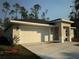 New construction home with a white garage door and nicely landscaped front yard at 1645 6Th Ave, Deland, FL 32724