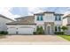 Two-story house with gray exterior, stone accents, and a three-car garage at 8042 Ludington Cir, Orlando, FL 32836