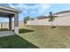 Spacious backyard featuring well-maintained lawn, pergola, and a privacy fence at 687 Campo Ln, Davenport, FL 33837