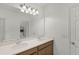 Clean bathroom featuring double sinks with ample counter space, wood cabinets, and a large mirror with modern lighting at 687 Campo Ln, Davenport, FL 33837