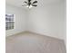 Bright, carpeted bedroom with a ceiling fan and a large window with blinds, offering a clean and minimalist design at 687 Campo Ln, Davenport, FL 33837
