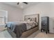 Comfortable bedroom featuring a queen-sized bed with patterned bedding, a side table, and neutral-colored walls and carpeting at 687 Campo Ln, Davenport, FL 33837