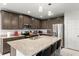 Stylish kitchen featuring granite countertops, stainless steel appliances, dark wood cabinetry, and a center island with bar seating at 687 Campo Ln, Davenport, FL 33837