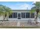 Exterior view of home's sunroom with rock landscaping, stepping stones and palm trees at 1366 Shipwreck Ln, Saint Cloud, FL 34771