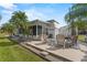 Cozy home exterior with a patio, seating, and tropical landscaping under a bright blue sky at 1366 Shipwreck Ln, Saint Cloud, FL 34771