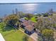 Stunning lakefront home featuring lush landscaping, screened lanai, and private dock at 128 W Juliana Way, Auburndale, FL 33823
