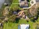 Breathtaking aerial view of lakefront property featuring lush landscaping and a private dock at 128 W Juliana Way, Auburndale, FL 33823