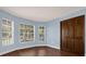 Bedroom featuring blue walls, wood flooring, a large closet and two windows with views of the outdoors at 128 W Juliana Way, Auburndale, FL 33823