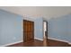 Bedroom featuring blue walls, wood flooring, a large closet and view of a door leading to another room at 128 W Juliana Way, Auburndale, FL 33823