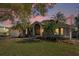 Charming single Gathering home with lush landscaping, mature palms, and a welcoming front porch at 128 W Juliana Way, Auburndale, FL 33823