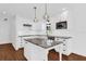 Modern kitchen features stainless steel appliances, white cabinets, granite countertops, and kitchen island at 128 W Juliana Way, Auburndale, FL 33823
