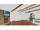 Bright, airy living room featuring vaulted ceilings, wood beams, stone fireplace, and staircase at 128 W Juliana Way, Auburndale, FL 33823